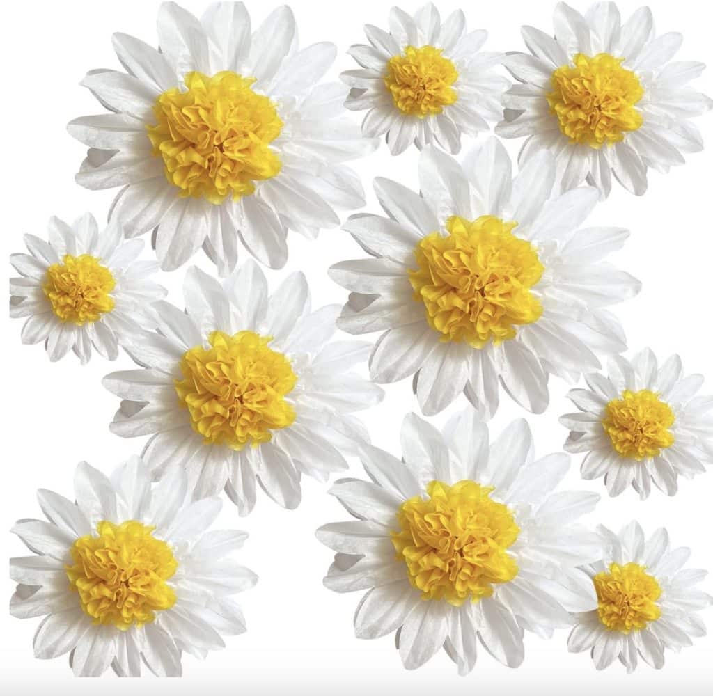 White daisies with bright yellow centers are scattered randomly against a white background, resembling an easy flower paper craft. The flowers vary in size, creating a vibrant and cheerful pattern.